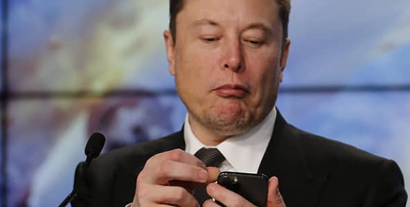 An image of Elon Musk looking at his phone